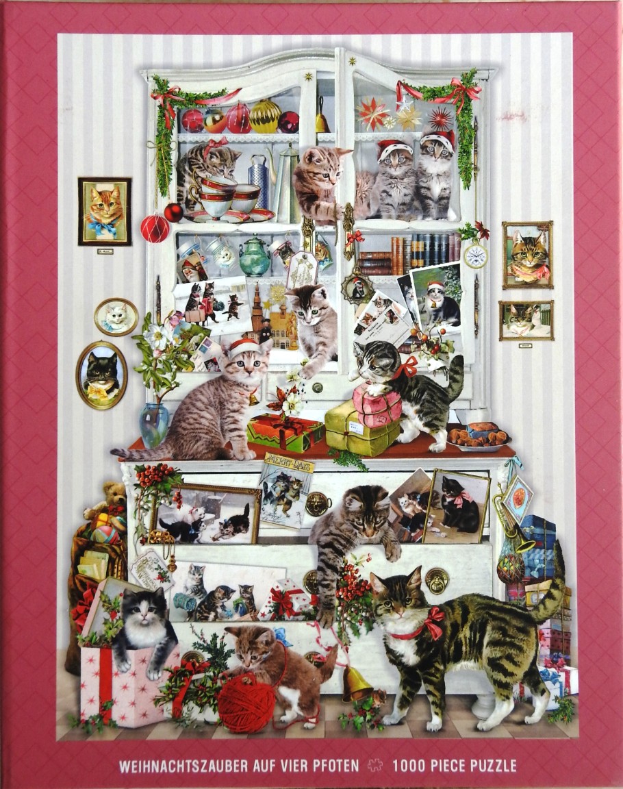 A festive scene featuring numerous kittens playing around a large white hutch decorated with Christmas ornaments.