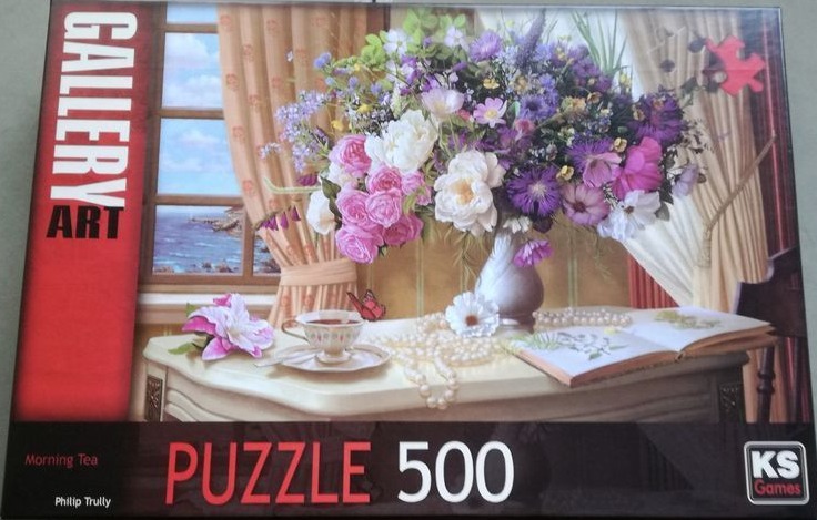 A lush bouquet of purple and white flowers in a vase on a table with tea and a book by a window.