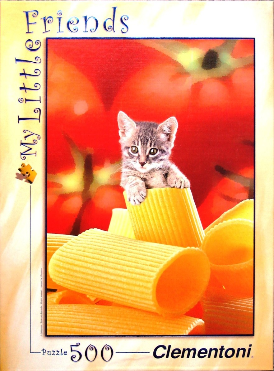 A small tabby kitten peeking out of a large rigatoni pasta tube against a bright red tomato background.