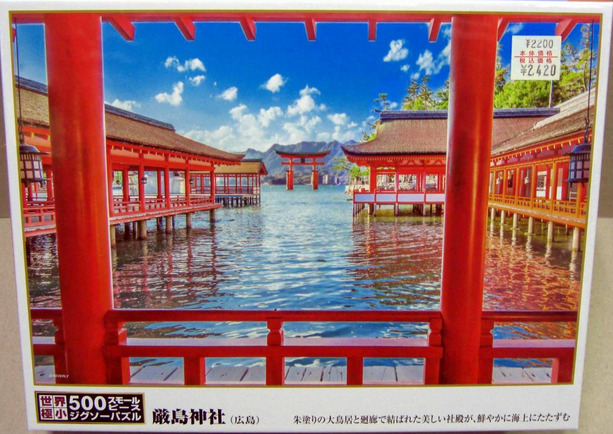 A view of the Itsukushima floating torii gate framed by the vibrant red wooden pillars of a traditional Japanese shrine.