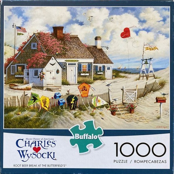 A beach house scene with colorful kites flying in the sky and on a picket fence.