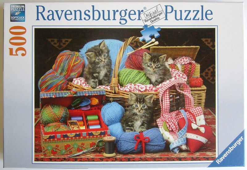 Three fluffy kittens playing among balls of yarn, sewing supplies, and baskets.