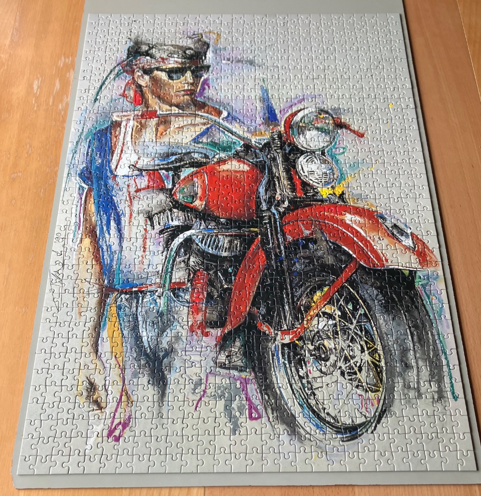 An expressionistic painting of a man with a bandana sitting on a bright red motorcycle against a neutral background.