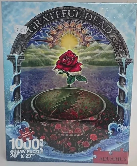 A red rose growing out of a skull landscape framed by a stone archway with water flowing down the pillars.