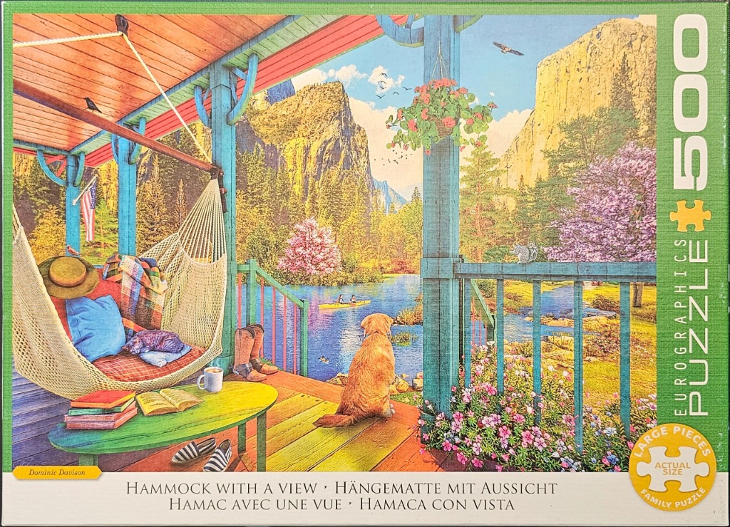 A golden retriever sits on a rustic wooden porch overlooking a mountain lake from a cozy hammock.