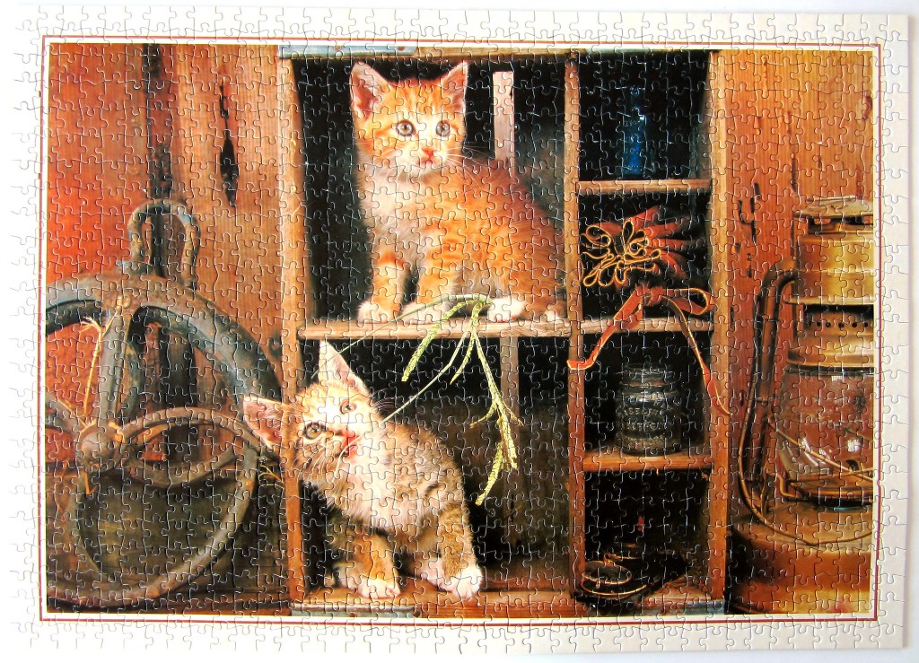 Two ginger kittens inside a rustic wooden cubby shelf with antique decorations.