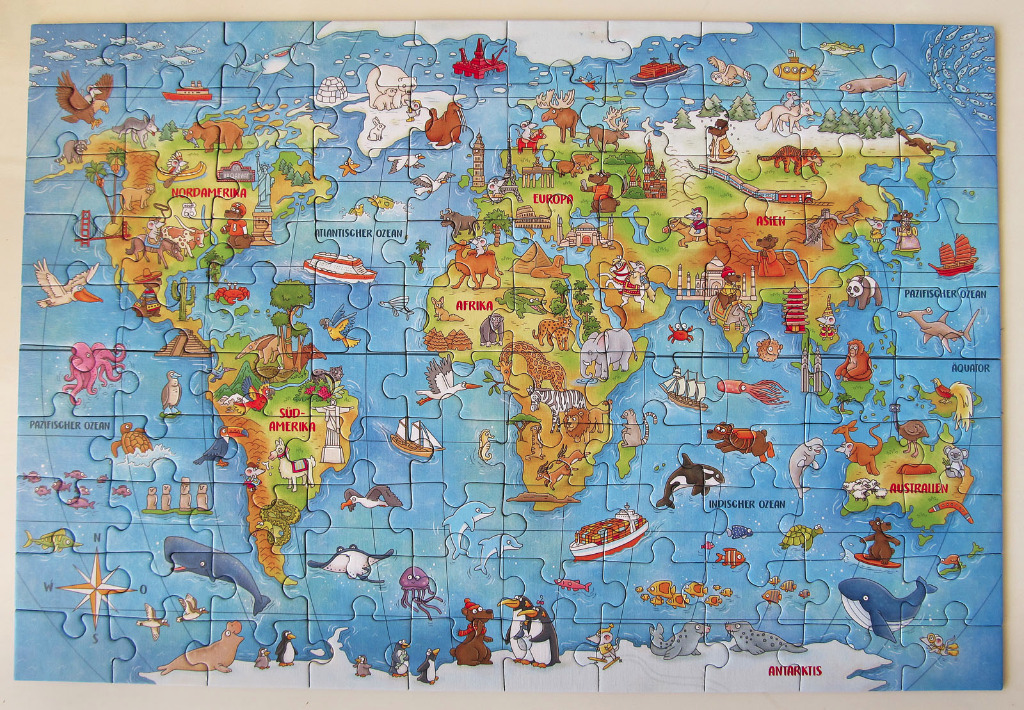 A colorful, illustrated world map featuring cartoon animals, landmarks, and marine life.