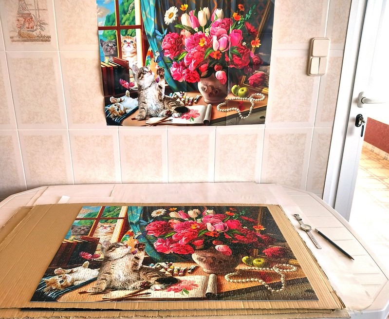 A scene featuring three cats interacting with a vibrant floral bouquet on a desk, echoed in both a wall image and a puzzle.