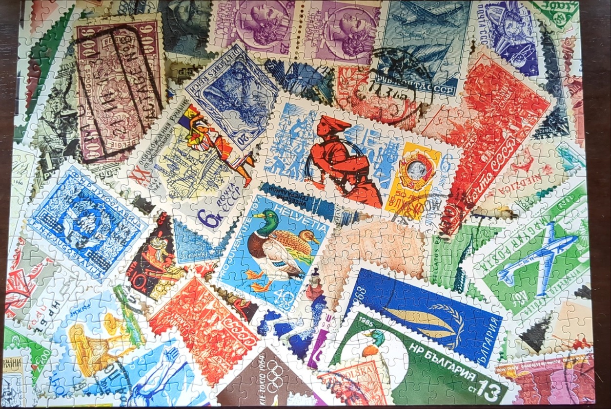 A collage of vintage international postage stamps in various shapes, sizes, and colors.
