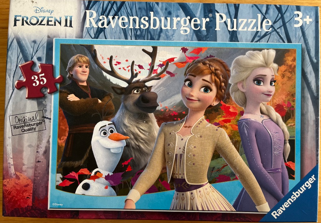Animated characters Anna, Elsa, Kristoff, Sven, and Olaf in a forest with autumn leaves.