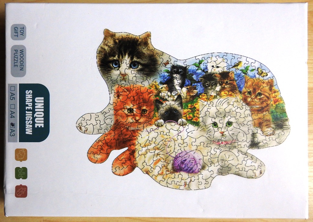 A group of cute kittens huddled together in a floral garden setting, printed in a distinct cat-shaped outline.