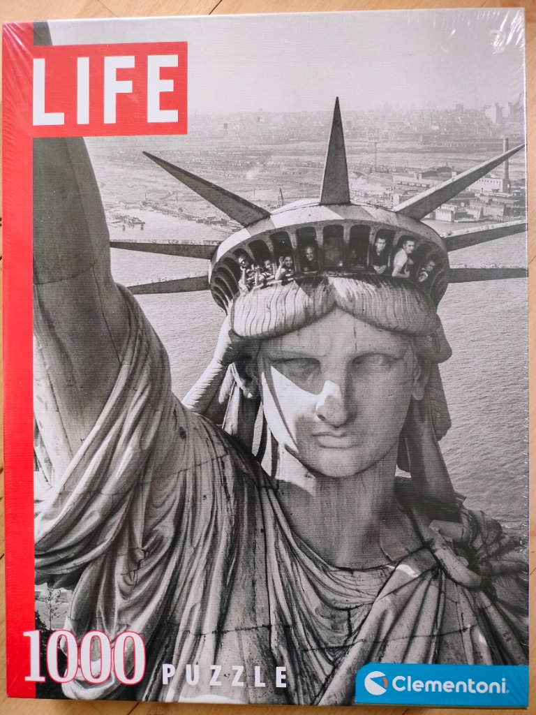 Black and white historical photograph of the Statue of Liberty crown looking out over the harbor.