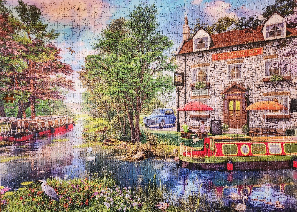 A peaceful English canal scene featuring the Riverside Inn, a narrowboat, and lush gardens.