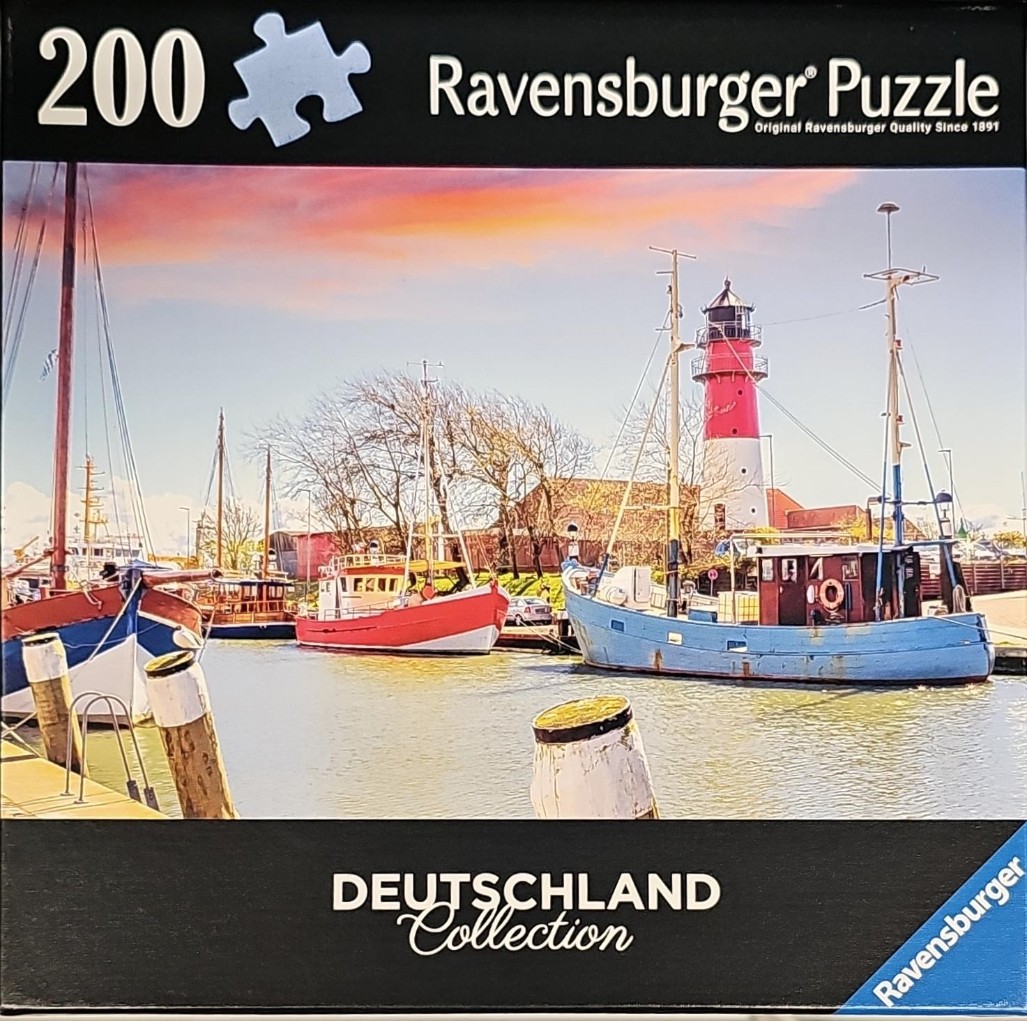 A peaceful harbor scene with colorful fishing boats and a lighthouse under a sunset sky.