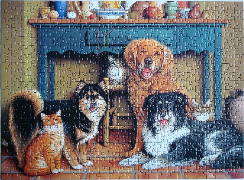 A group of dogs and cats gathered in a cozy kitchen setting under a blue table.