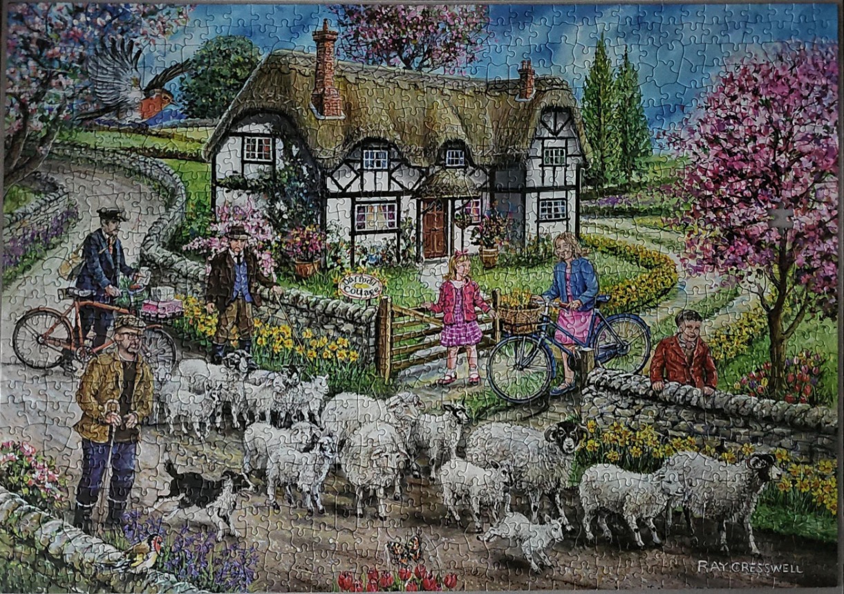 A countryside scene featuring a thatched-roof cottage, a shepherd with sheep, and people on bicycles.