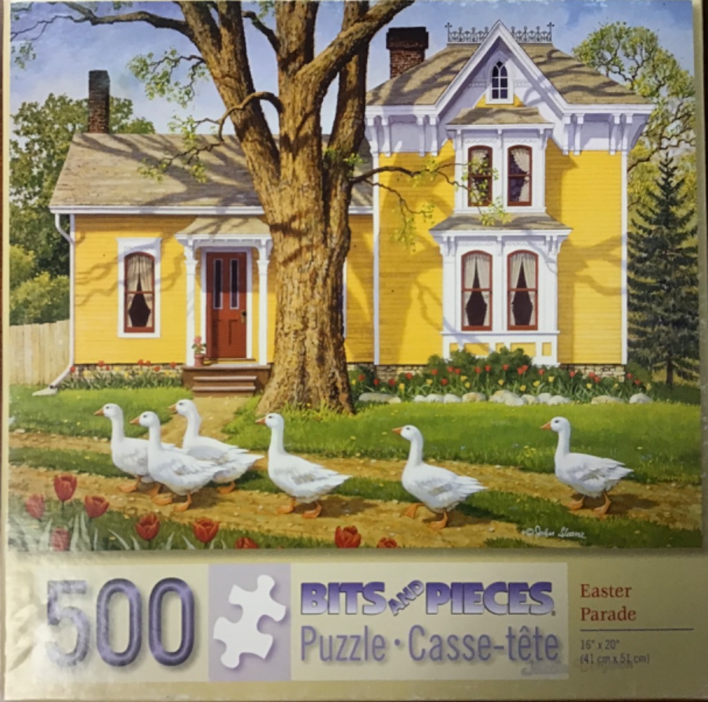 A row of white geese walking across a lawn in front of a yellow Victorian house