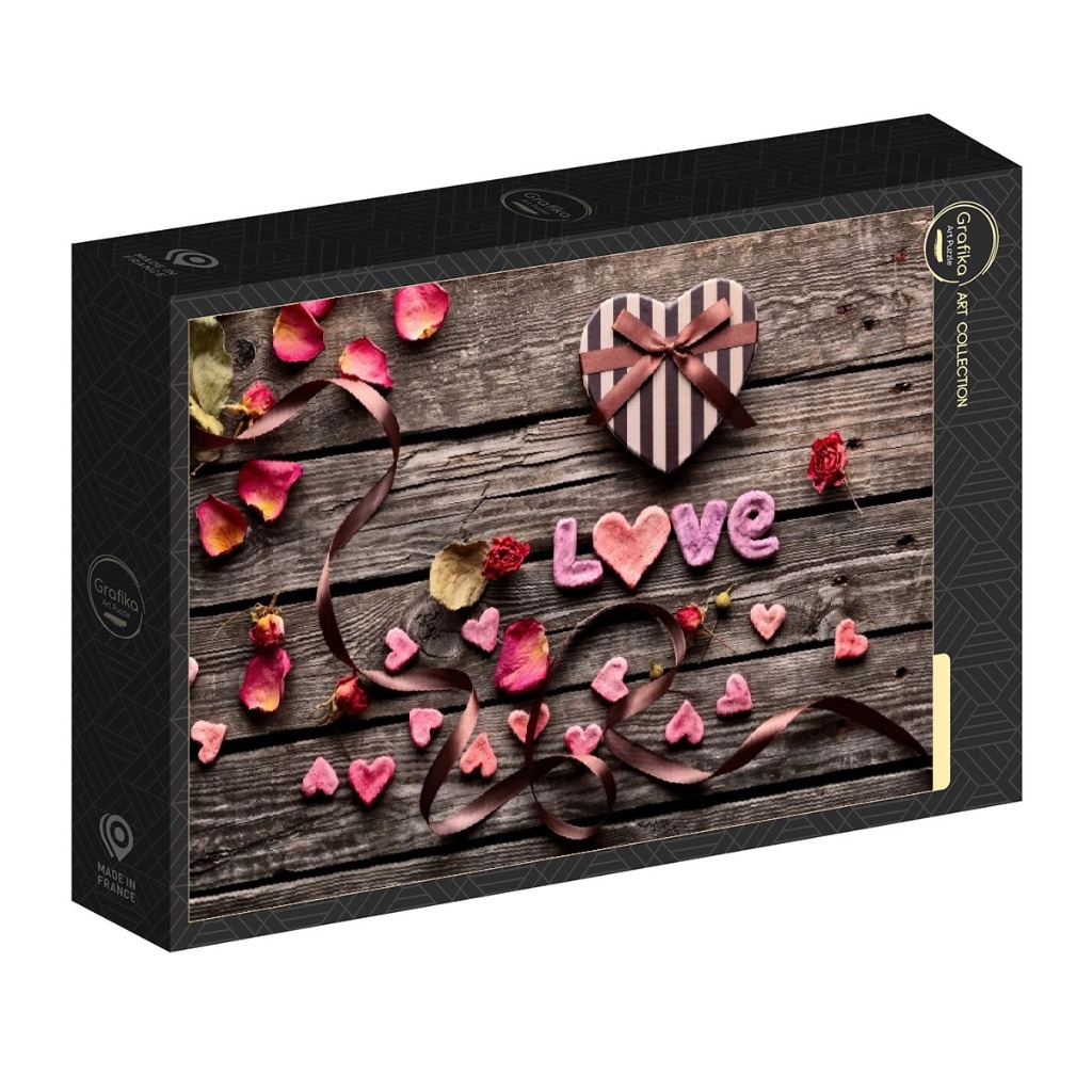 A romantic flat-lay scene with a heart-shaped box, flower petals, and the word LOVE spelled out on rustic wood planks.