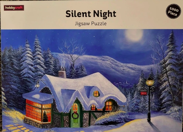 A cozy stone cottage in a snowy, moonlit forest setting at night.