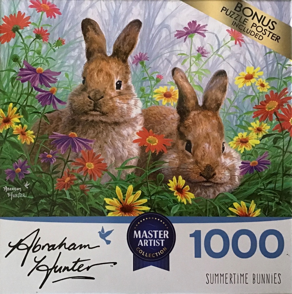 Two brown rabbits sitting in a meadow of colorful wildflowers.