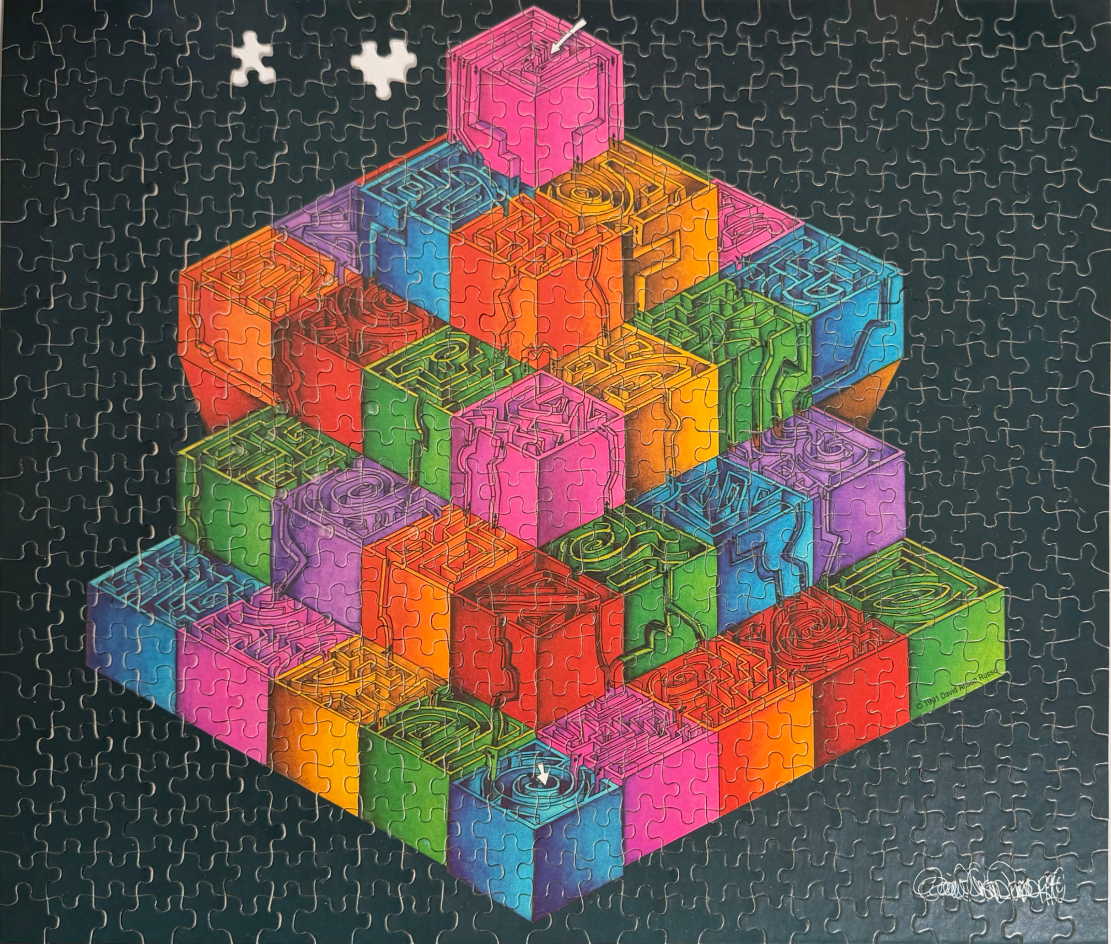 A 3D pyramid made of colorful, glowing maze-filled cubes against a black background.