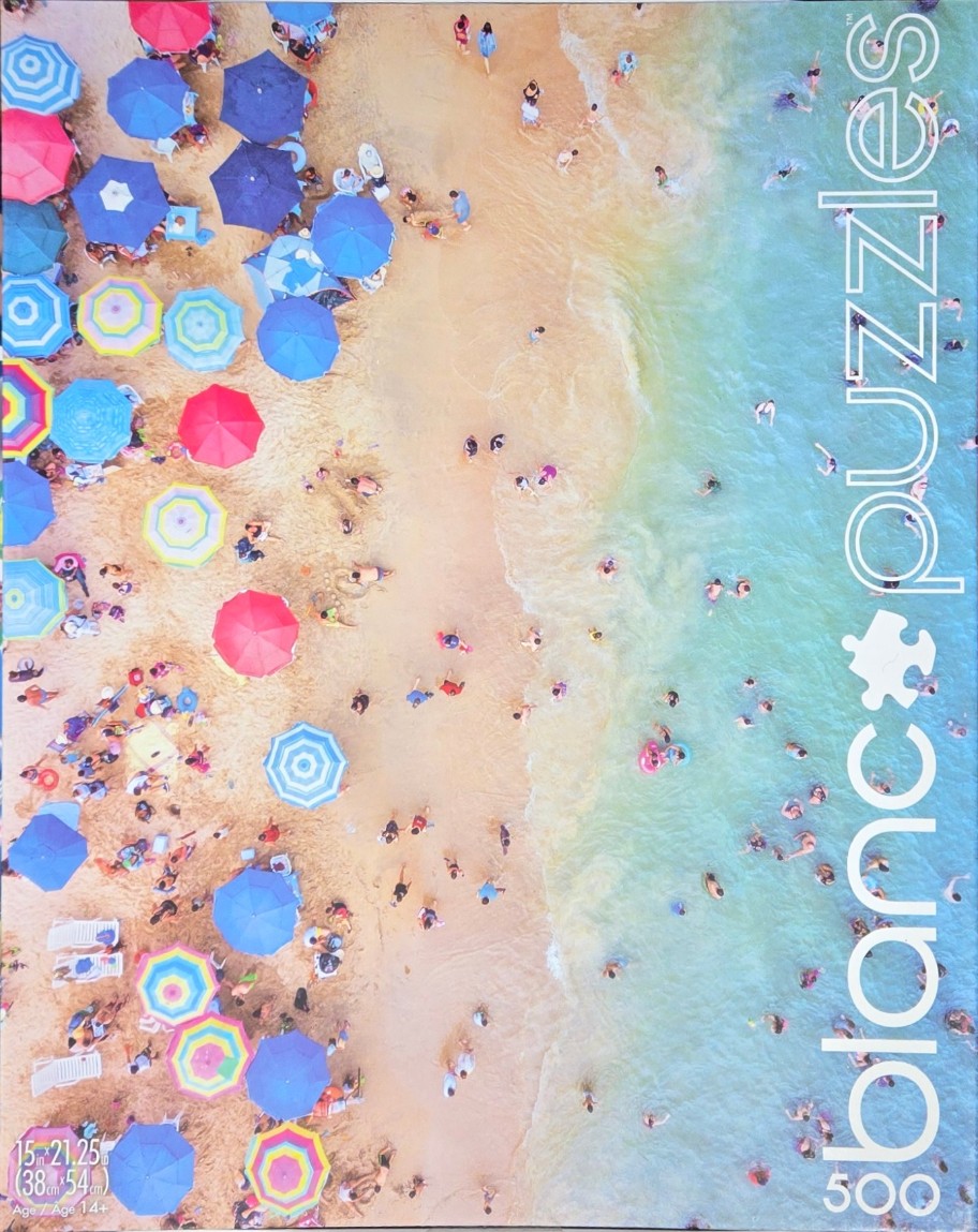 Aerial view of a crowded tropical beach with colorful umbrellas and swimmers in turquoise water.