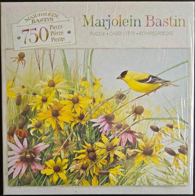 A goldfinch perched on a grass stem amidst a field of yellow coneflowers and purple coneflowers.