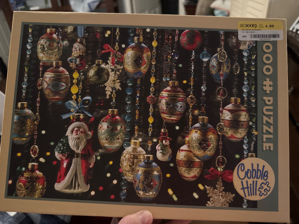 A collection of vintage Christmas tree ornaments hanging at various heights against a dark, bokeh-lit background.