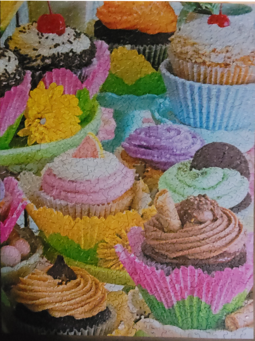 An assortment of vibrant, decorated cupcakes in colorful paper liners.