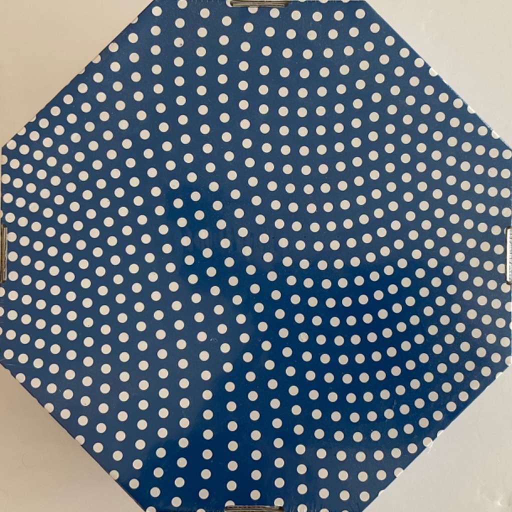An octagonal shape covered in a pattern of white polka dots on a blue background.