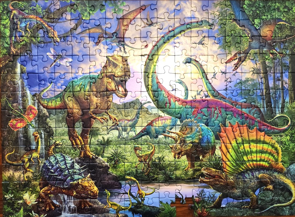 A lush prehistoric jungle scene filled with various dinosaurs, pterosaurs, and dragonflies under a golden sun.