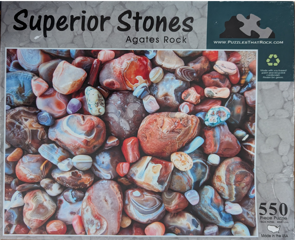 A collection of smooth, polished agates and colorful stones in varying shades of red, blue, and brown.