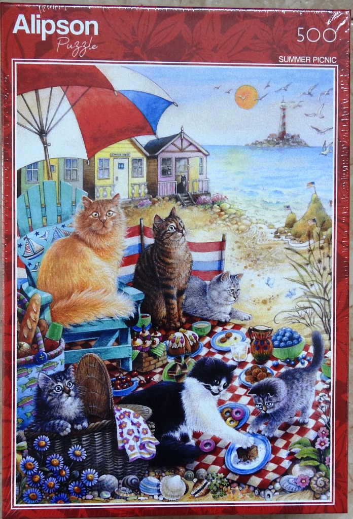 Six cats enjoying a sunny picnic on a beach in front of colorful seaside beach huts and a lighthouse.