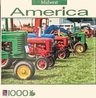 A row of vintage colorful tractors parked in a grassy field.