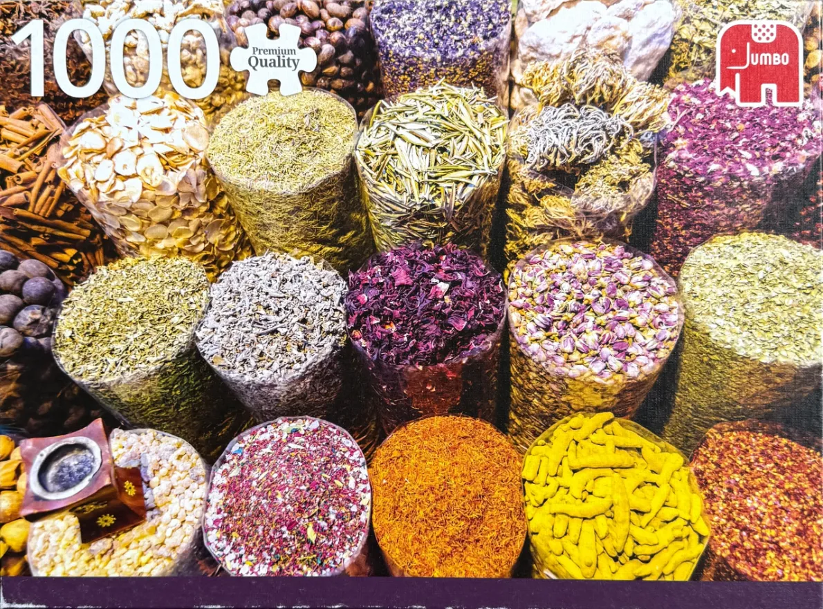 A high-angle view of many clear plastic bags filled with various colorful spices, herbs, and dried flowers.