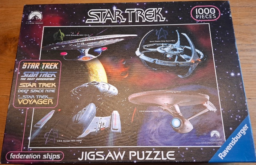 A montage of four iconic Starfleet vessels and a space station set against a vibrant deep space background.