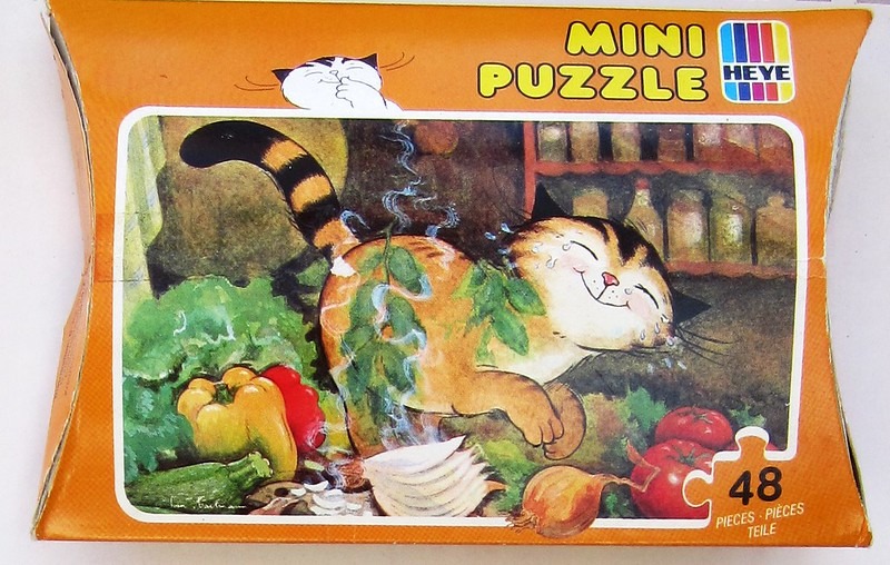 Cartoon illustration of a ginger tabby cat crying while chopping an onion amongst kitchen vegetables.