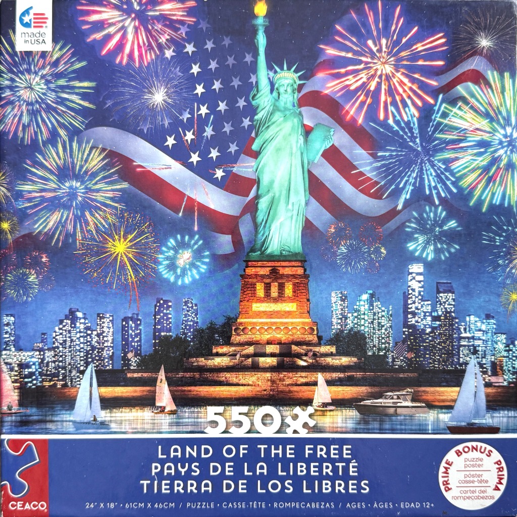 The Statue of Liberty stands tall before a waving American flag and colorful fireworks over a city skyline at night.