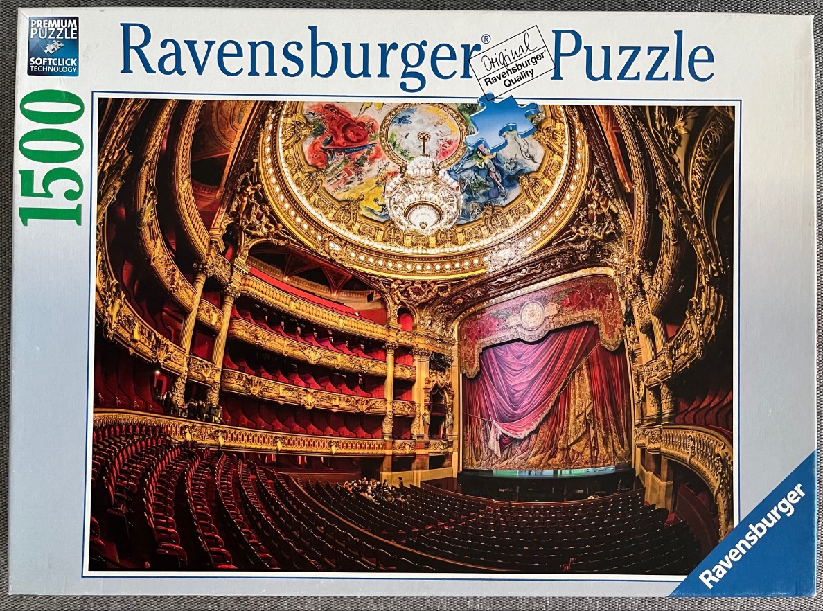 Interior view of the opulent Opera Garnier in Paris, featuring red velvet seating and a grand ornate ceiling.