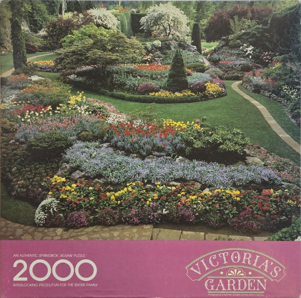 A lush, multi-level botanical garden scene filled with vibrant flower beds, green lawns, and winding stone paths.
