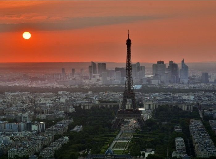 A golden sunset glows over the Eiffel Tower and the Parisian skyline.