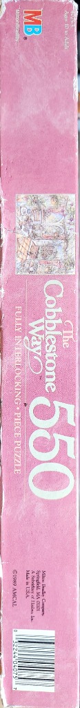 Pink box with a colorful scene of a town square. The text reads "The Cobblestone Way" and "500".