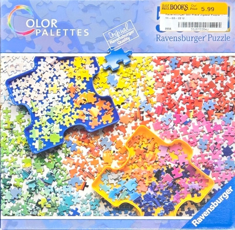 A top-down view of scattered jigsaw puzzle pieces organized into colorful piles and trays.