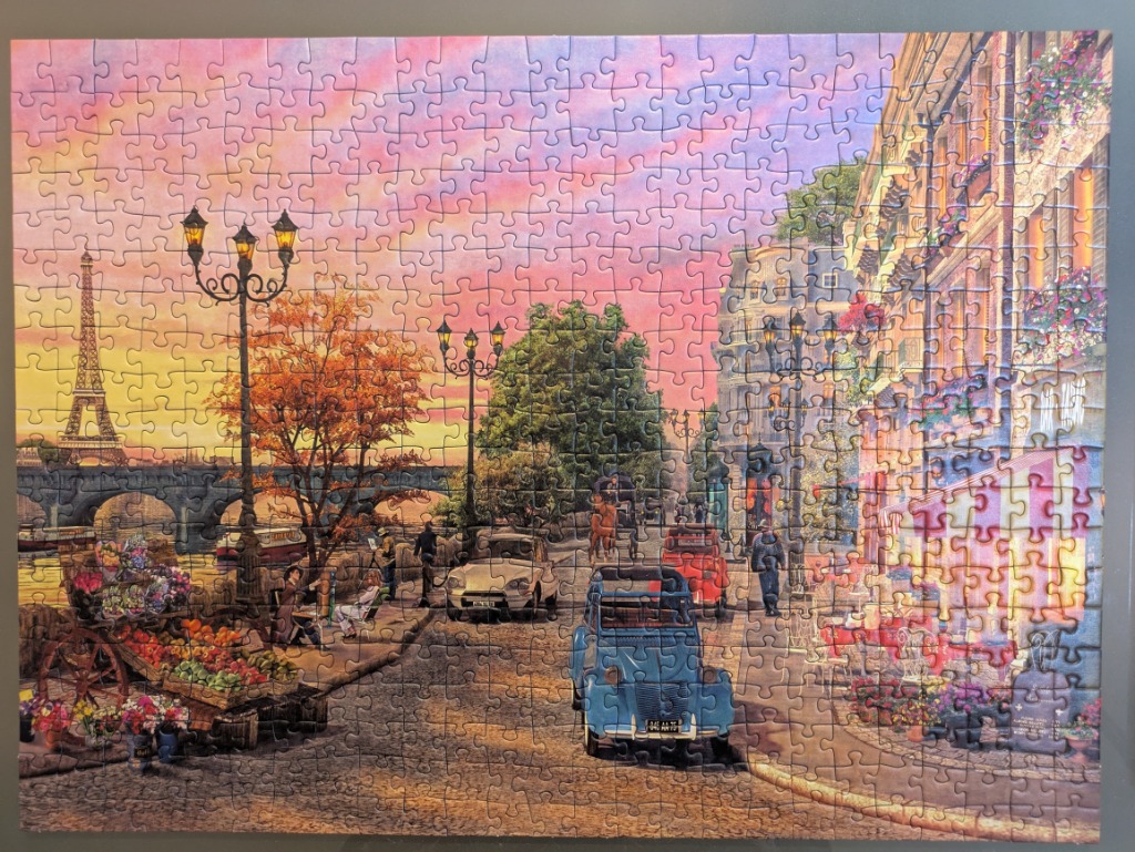 A romantic Paris street scene at sunset featuring the Eiffel Tower and vintage cars.