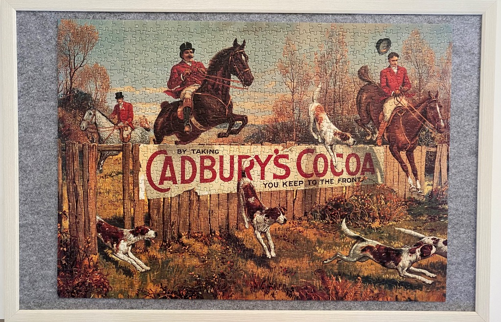 A vintage advertisement illustration depicting fox hunters on horseback jumping over a wooden fence with hunting dogs.