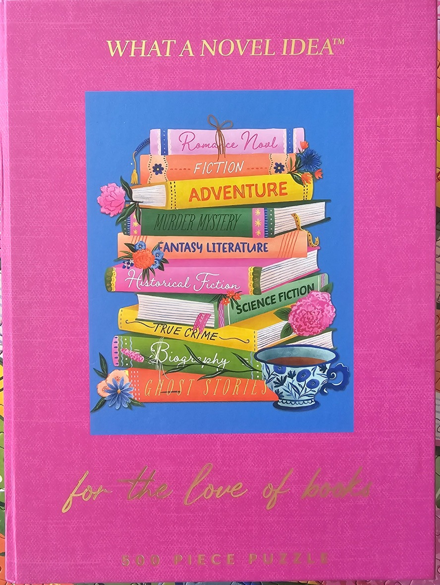 An illustration of a colorful stack of books with floral accents and a teacup against a solid pink background.