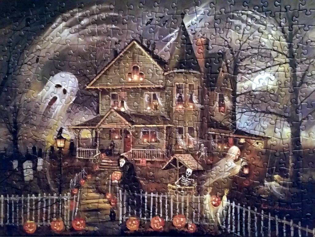 An illustration of a spooky haunted house at night, filled with ghosts, skeletons, and jack-o