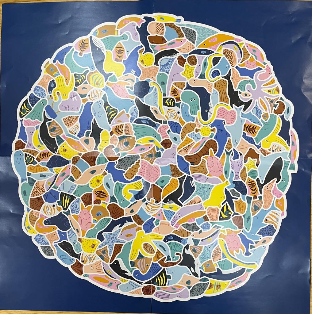 A dense, circular illustration of various sea creatures packed together against a deep blue background.