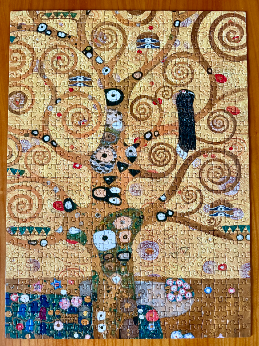 A section of Gustav Klimt's The Tree of Life painting featuring swirling gold branches and a patterned tree trunk.