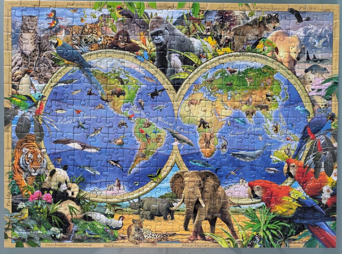 A detailed world map illustration surrounded by a collage of various wild animals and birds.